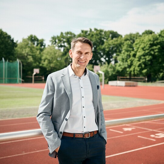 Business-Portrait im hellen Sakko an authentischem Ort